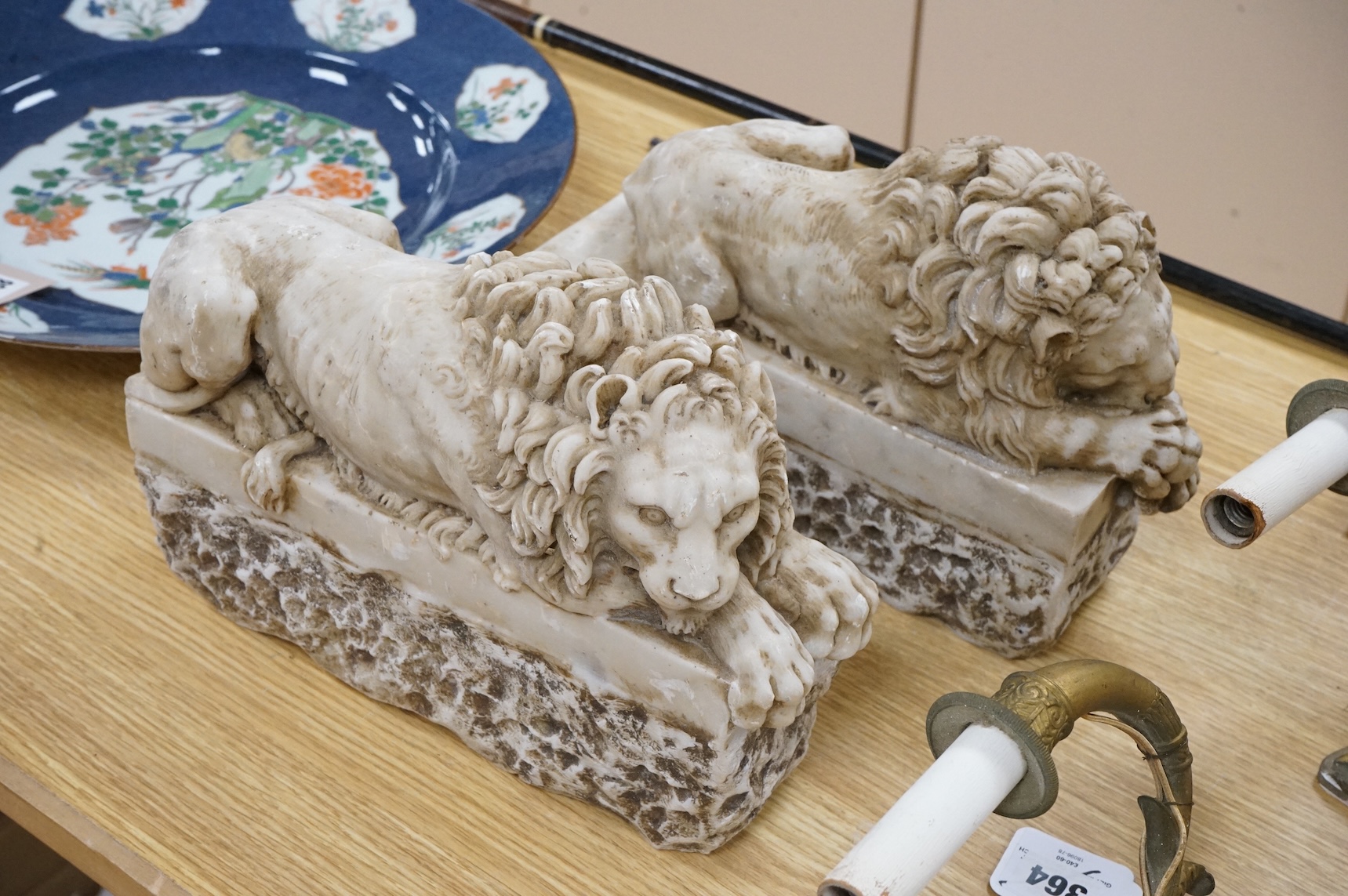 A pair of marble resin Canova lions, 30cm wide
